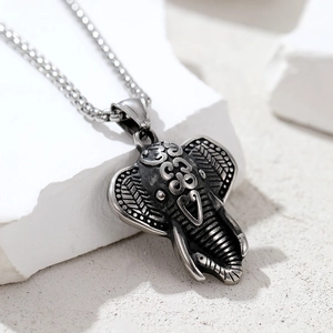 Detailed close-up of retro elephant pendant with tribal engravings and metal chain