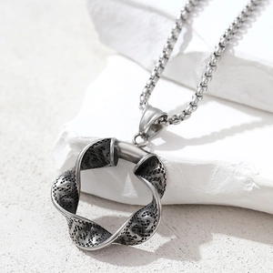Close-up of twisted round pendant with woven mesh texture on stainless steel chain