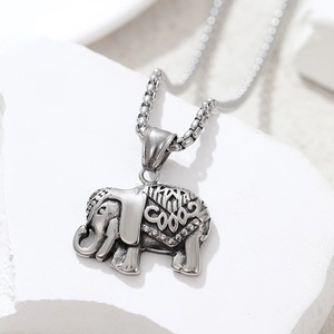 Macro detail of retro stainless steel elephant pendant with intricate geometric engravings