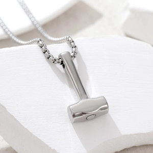 Detail of silver hammer pendant on white stone texture for stainless steel necklace
