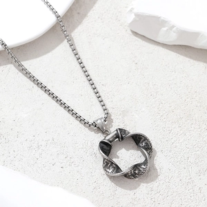 Vintage stainless steel necklace featuring a textured mobius loop pendant on a box chain