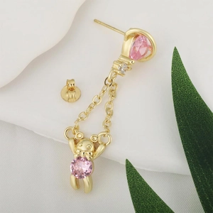 Retro Saturn Bär Ohrstecker mit rosa Zirkon und Goldkette auf weißem Hintergrund