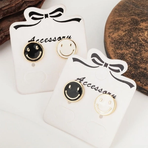 Boucles d'oreilles smiley en émail noir et blanc sur cartes de présentation