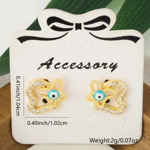 Detailed view of gold heart stud earrings with blue evil eye and sparkling zircon stones