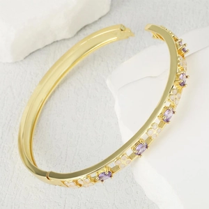 Elegant gold-plated hinged bangle with purple gemstones and white clover patterns