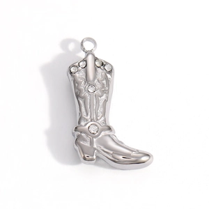 Dettaglio di un ciondolo a stivale da cowboy in argento con motivi western e strass