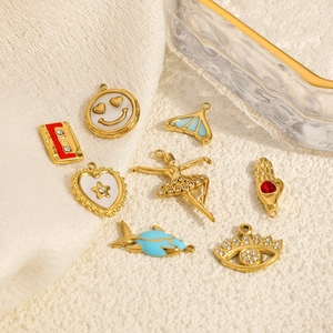 Detailed macro view of 14k gold plated charms with enamel and cubic zirconia insets