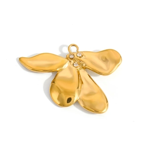 Detailed view of irregular petal-shaped gold pendant with three sparkling rhinestones