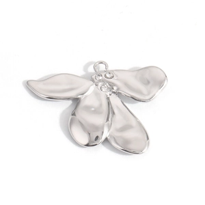 Macro shot of silver metallic flower charm with three inlaid crystals for DIY jewelry making