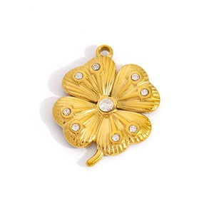 Golden clover pendant with starburst texture and sparkling rhinestones on white background
