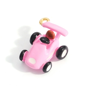 Close-up of cute pink racing car charm with enamel finish and gold metal ring