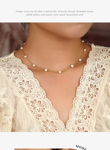 Gedetailleerde close-up van een gouden ketting met gelijkmatig verdeelde witte zoetwaterparels