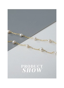 Macro-opname van een minimalistische gouden ketting met kleine witte zoetwaterparels