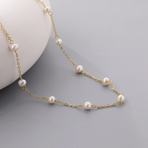 Elegante gouden ketting met glanzende witte zoetwaterparels voor een moderne chique look
