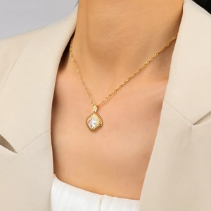 Elegante gouden ketting met geribbelde hanger en zirkoon aan een gedraaide ketting