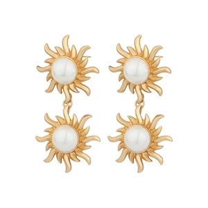 Detail of vintage French gold sun earrings with embedded pearls and metallic texture