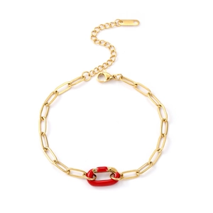 Dettaglio di un bracciale a catena a graffetta dorata con elemento in smalto rosso vivo