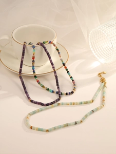 Detail view of colorful bohemian handmade stone bead necklaces with golden lobster clasp