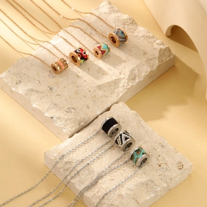 Collier bohème en acier titane avec perles colorées exposé sur décor en pierre
