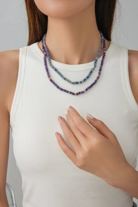 Detail of double-layered bohemian necklace with purple, blue beads and gold accents