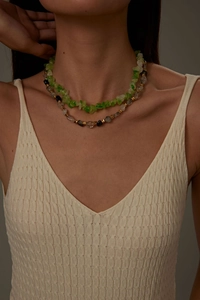Detail of vintage layered beaded necklace featuring green stones and gold metal spacers