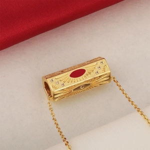 Gold-plated rectangular pendant with red enamel eye and sunburst crystal accents