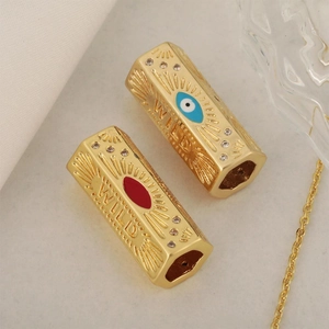 Gold plated hexagonal charm with evil eye detail, sunburst pattern and WILD engraving
