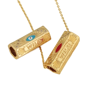 Gold hexagonal tube pendant with Evil Eye symbol and WILD engraving with zircon stones