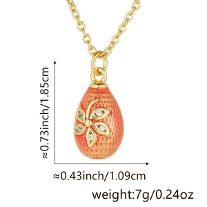 Detail of 18k gold plated egg pendant with orange enamel and diamond flower pattern