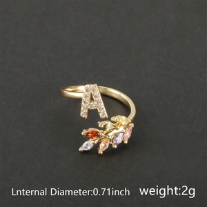 Close-up of 18k gold ring with letter A and multi-color marquise gemstones detail