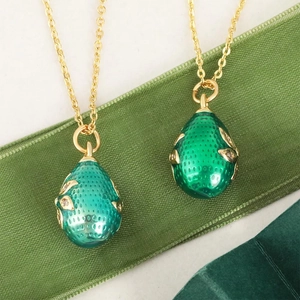 Vintage 18k gold plated egg pendants with green enamel and sparkling diamond leaf detail