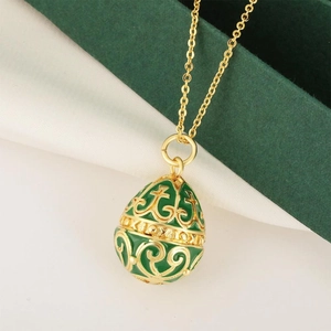 Green enamel egg pendant necklace with intricate vintage gold floral patterns