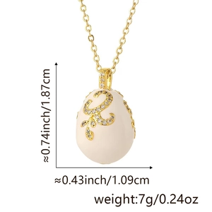 Detail view of Faberge style egg pendant with gold scrollwork and rhinestones