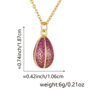 Macro shot of egg-shaped pendant with gold honeycomb texture and magenta enamel detail