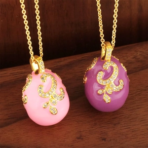 Luxury Russian-style enamel egg pendants in pink and purple with gold scrollwork and zircons