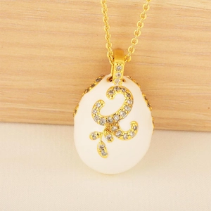 Exquisite gold egg pendant necklace with white enamel and sparkling crystal details