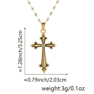 Detailed view of gothic gold-plated cross pendant with black enamel and clear gemstone