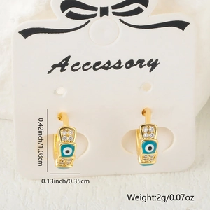 Detail shot of Evil Eye earrings with blue enamel, cubic zirconia, and dimensions info