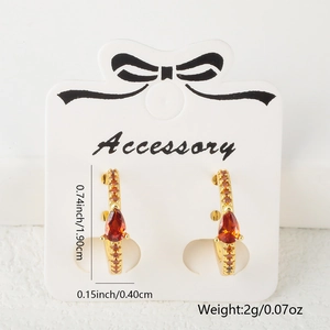 Macro de boucles d'oreilles dorées avec zircon orange et détails de dimensions