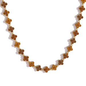 Detailansicht der Goldkette mit Kleeblatt-Anhängern und bernsteinfarbenen Kristallen