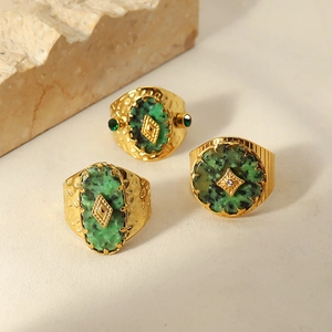 Gedetailleerde close-up van vintage 18k vergulde ringen met natuurlijke groene stenen