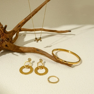 Detailopname van gouden sieradenset met zirkonia ketting, armband, oorbellen en ring
