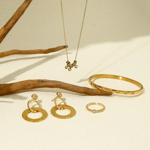 Gouden sieradenset met strass-ketting, armband, oorbellen en ring op houten decoratie