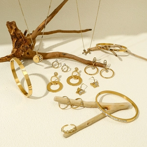 Detail van een goudvergulde sieradenset met witte zirkoon op een houten displayhouder