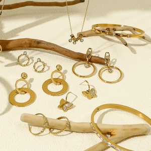 Elegante gouden sieradenset met ketting oorbellen en armbanden op houten takje