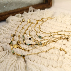 Detail of layered gold bracelets with turquoise beads and hammered round charms
