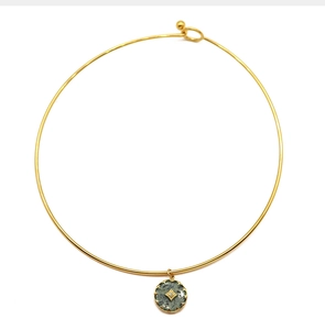 Detail of gold choker collar with natural stone pendant and engraved star accent