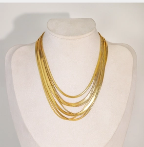 Detail of layered gold snake bone chains showing high-quality metallic finish and textures