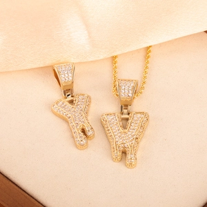 Macro detail of gold plated hip hop bubble letters Y and W with pave set zircon stones