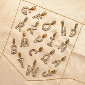 Pendenti con lettere dell'alfabeto in rame placcato oro 18K con zirconi su seta champagne